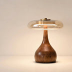Table lamp with solid walnut timber base and tinted glass disc, warm ambient LED light