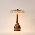Table lamp with solid walnut timber base and tinted glass disc, warm ambient LED light