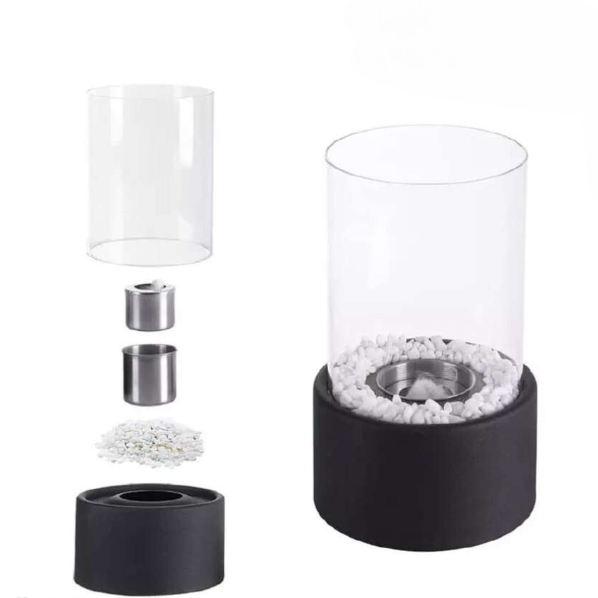 Oil lamp with open flame in clear glass cylinder on metal frame with decorative stones