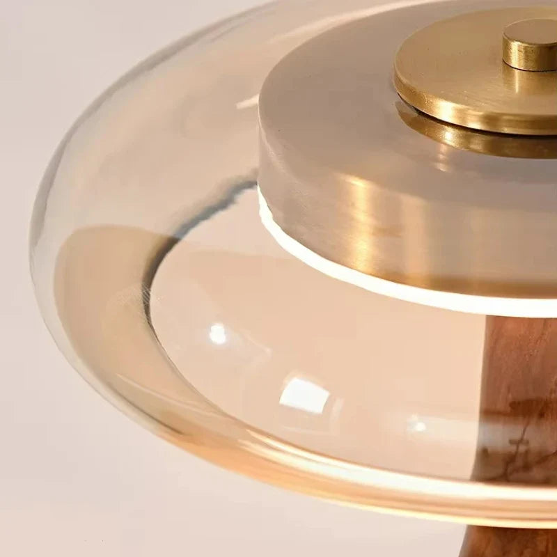 Table lamp with solid walnut timber base and tinted glass disc, warm ambient LED light