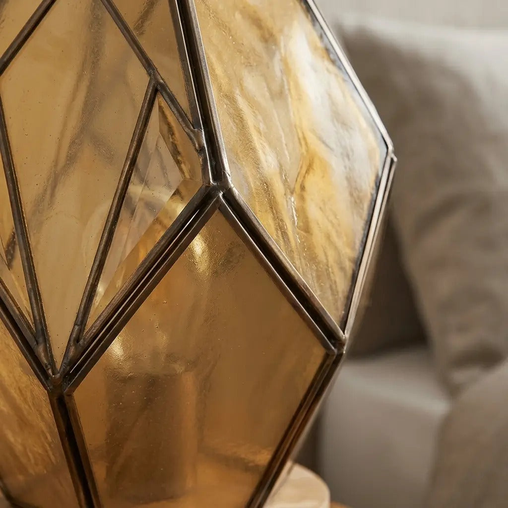 Geometric glass table lamp amber with wood base and exposed metal profiles, warm diffused light