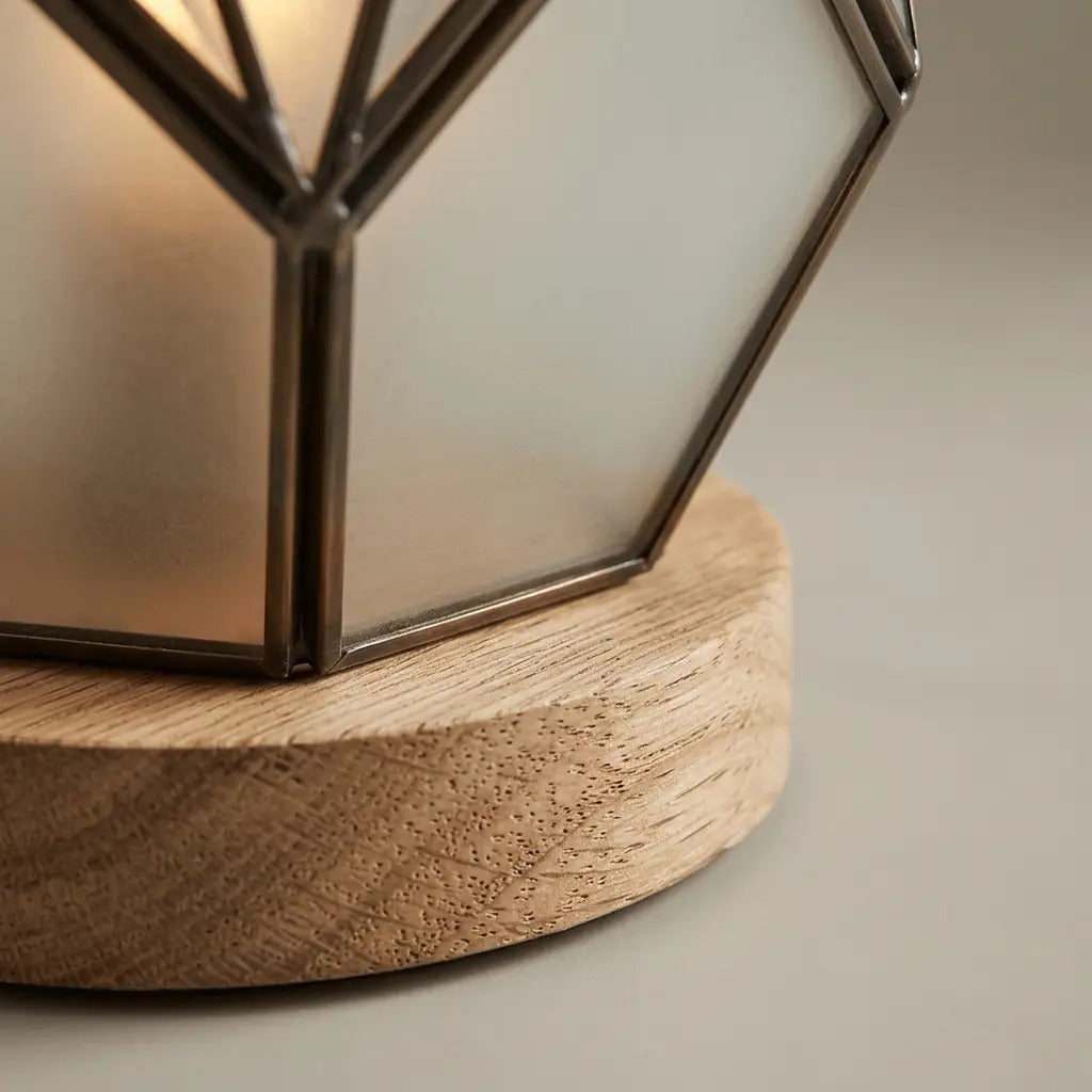 Geometric glass table lamp amber with wood base and exposed metal profiles, warm diffused light