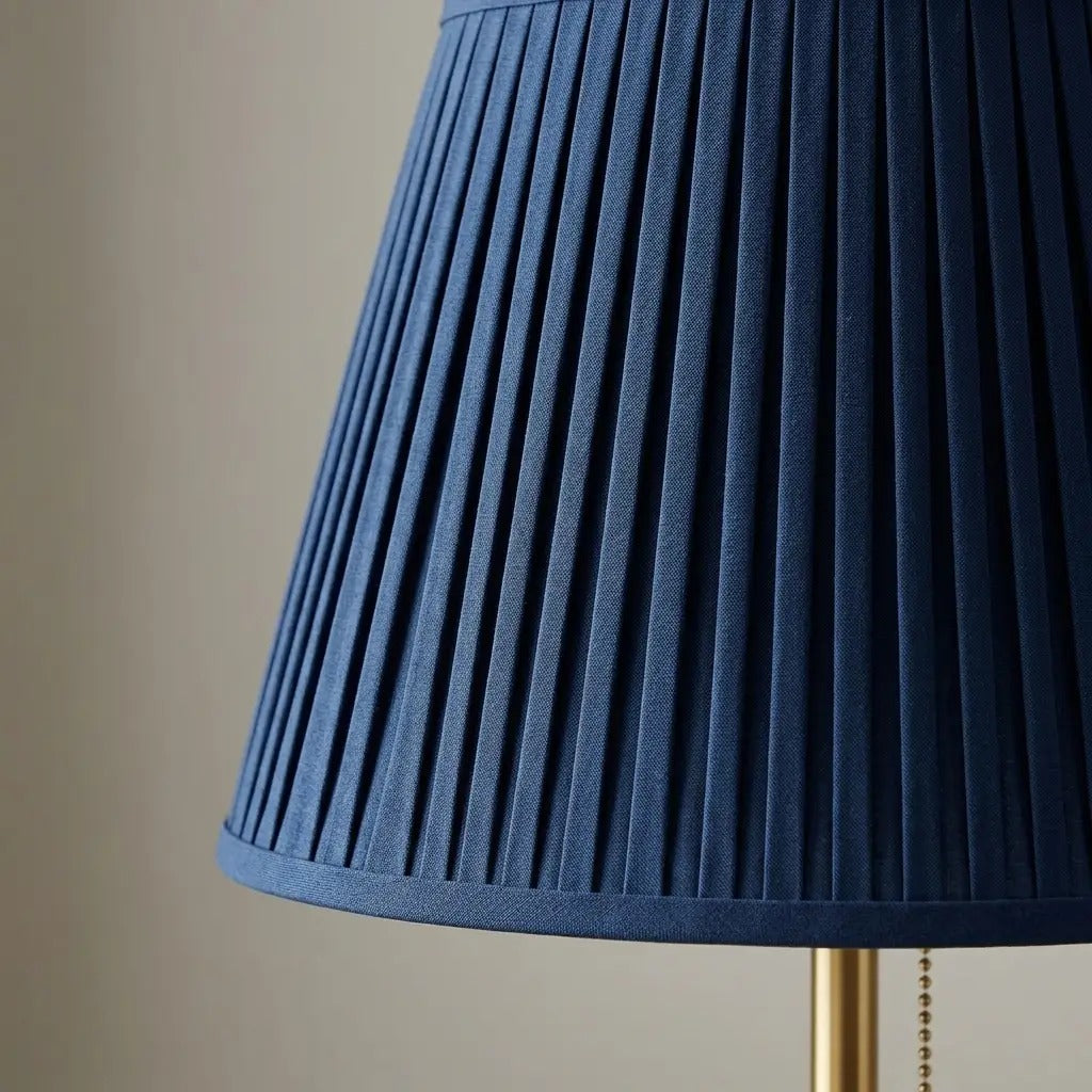 Table lamp with blue pleated fabric shade and brass metal base, soft ambient light