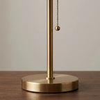 Table lamp with blue pleated fabric shade and brass metal base, soft ambient light
