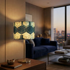 Table lamp with geometric patterned cylindrical shade and brass metal base, warm diffused light