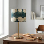 Table lamp with geometric patterned cylindrical shade and brass metal base, warm diffused light